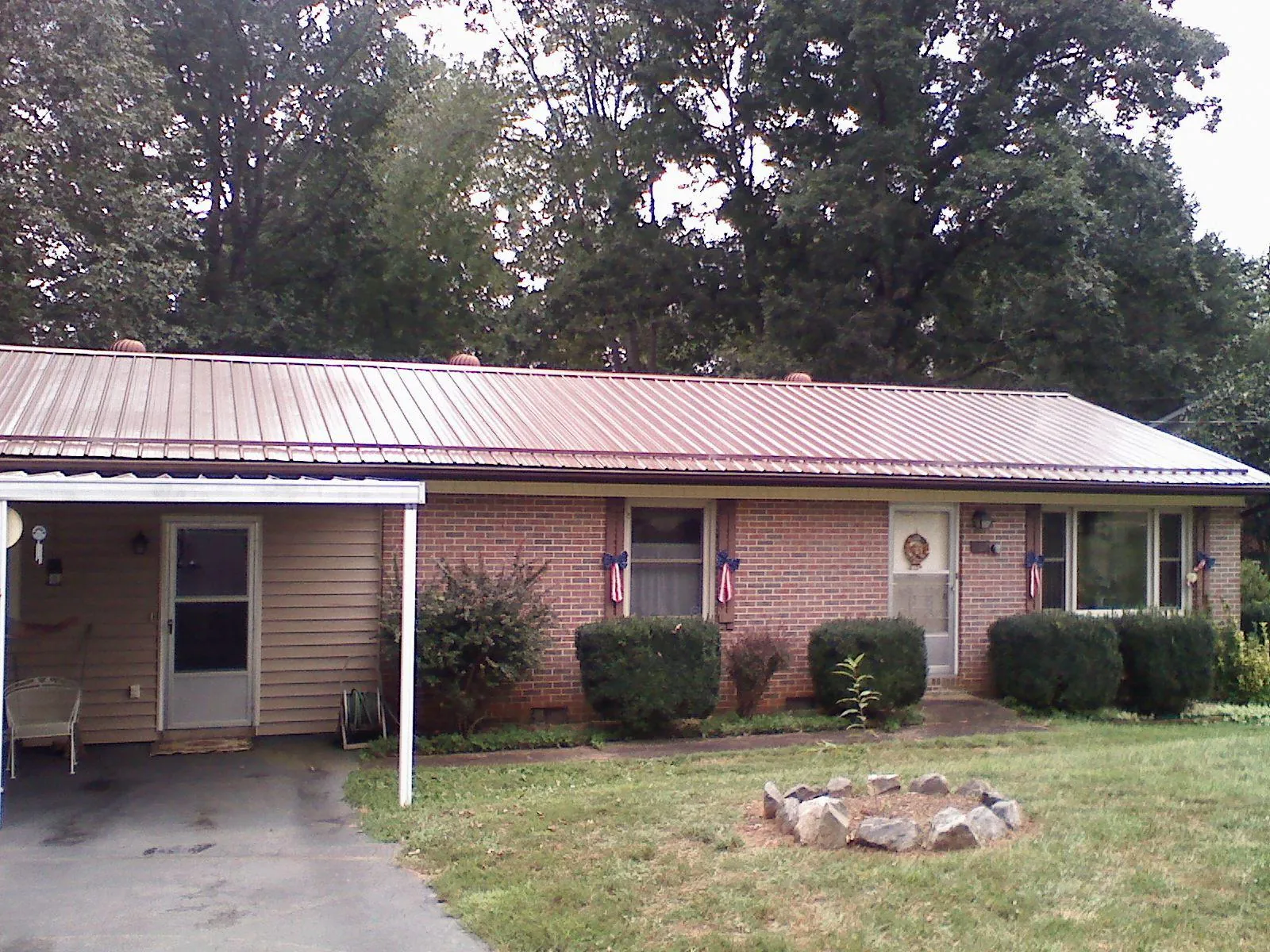 Bronze metal roof and carport on a brick ranch home — Roof Repair work by our crew in Ravenna